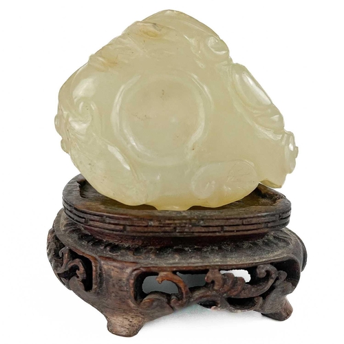 1056 - A Chinese mutton fat jade brush pot, 19th century Carved with foliage, on a carved hardwood stand, h... 