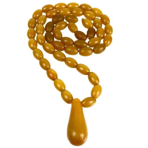 1086 - A butterscotch 'amber' style oval bead necklace. With a large pear shaped pendant, length of pendant... 