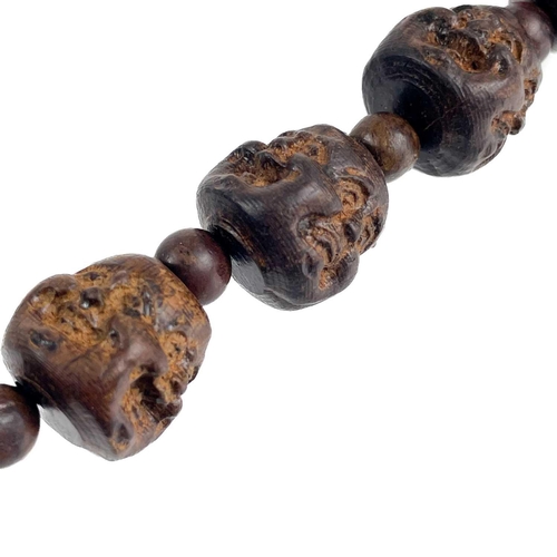 1089 - A strand of five Chinese carved hardwood Buddha head beads. Each comprising of four jovial and sad f... 