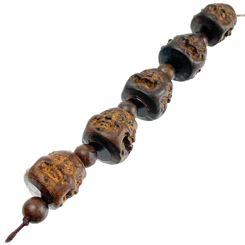 1089 - A strand of five Chinese carved hardwood Buddha head beads. Each comprising of four jovial and sad f... 