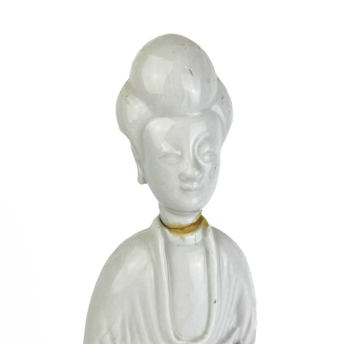 1112 - A Chinese blanc de chine figure of Guanyin, 18th/19th century. Stood holding a child in her arms, he... 