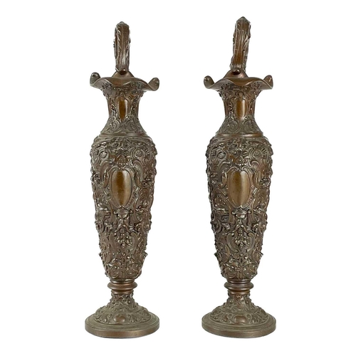 106 - A pair of metal pedestal jugs. cast with foliate and scroll detail, in a neo classical style, height... 