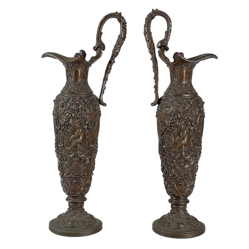 106 - A pair of metal pedestal jugs. cast with foliate and scroll detail, in a neo classical style, height... 