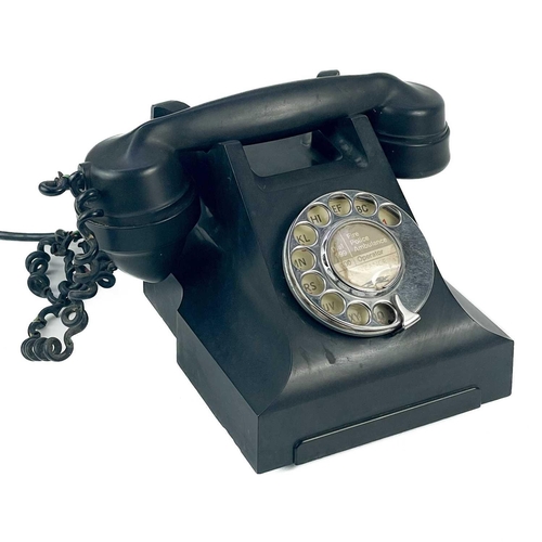 134 - A black Bakelite telephone circa 1930. Central paper label Penzance, together with a large pewter ca... 