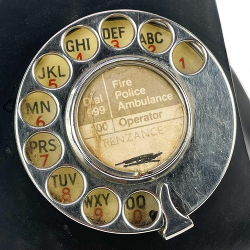 134 - A black Bakelite telephone circa 1930. Central paper label Penzance, together with a large pewter ca... 