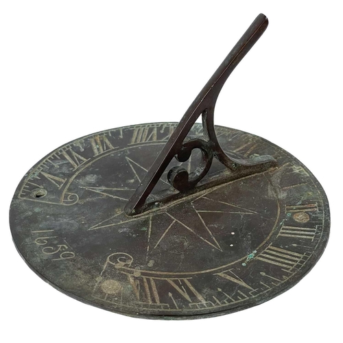 135 - A bronze circular sundial with gnomon and compass rose decoration. Diameter 15cm, together with a mu... 