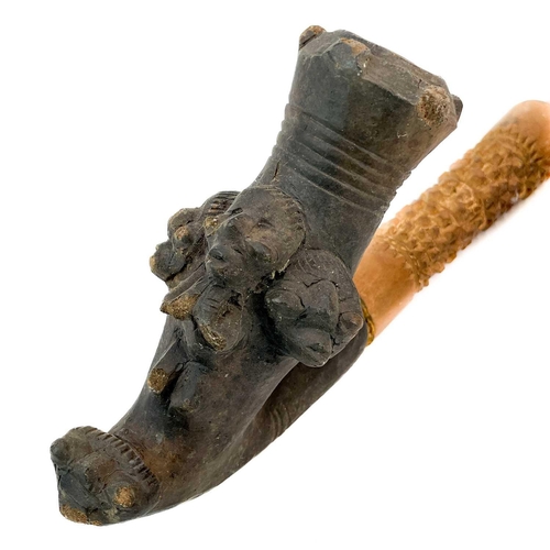 179 - An African clay pipe. Moulded with three heads, length 54cm, together with three other similar pipes... 