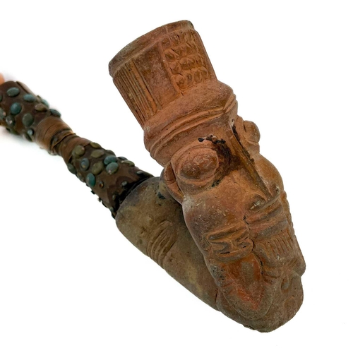 179 - An African clay pipe. Moulded with three heads, length 54cm, together with three other similar pipes... 