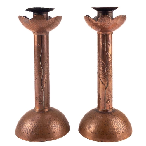 2 - Herbert Dyer (1898-1974). A pair of Cornish copper candlesticks with repousse and chased decoration ... 