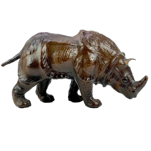 210 - A leather model of a rhinoceros. Height18.5cm, length 32cm.