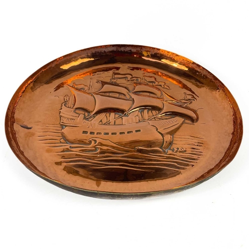 213 - A Newlyn copper circular shallow dish. Repousse and chased decorated with a galleon, diameter 33cm. ... 