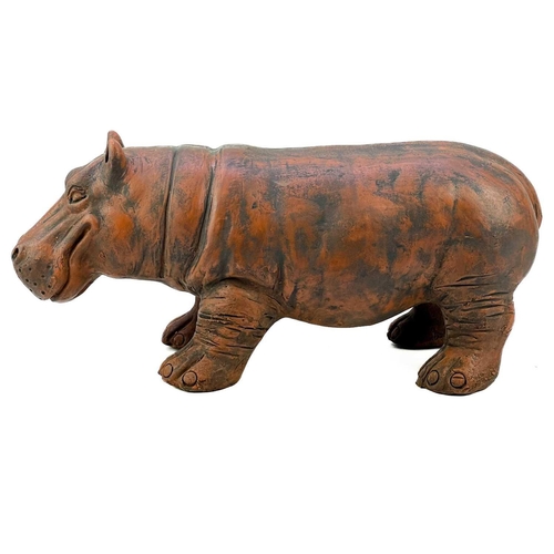 214 - A sculpture of a hippo cast in terracotta. Height 23cm, length 51cm.