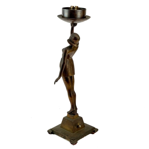 222 - An Art Deco cast metal figural table lamp. Modelled as a standing female dancer holding a large glas... 