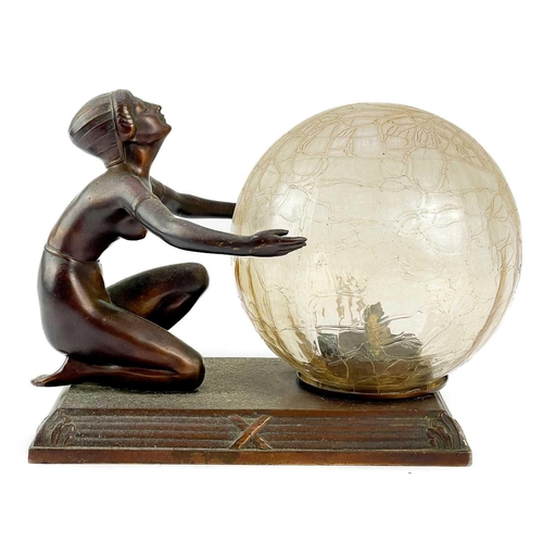 222 - An Art Deco cast metal figural table lamp. Modelled as a standing female dancer holding a large glas... 