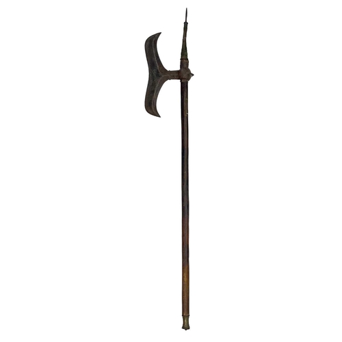 298 - An Indian battle axe. 19th century, with waved steel blade and pointed finial with wooden shaft, len... 