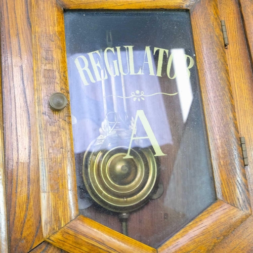 319 - A Regulator A drop dial wall clock. With a circular brass dial in an elm case, height 56cm, diameter... 