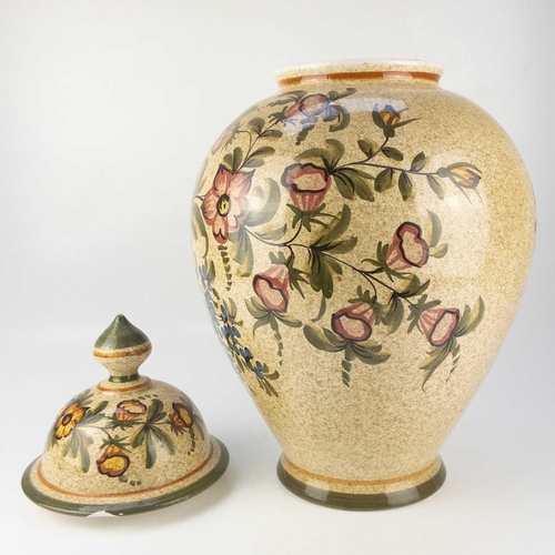 424 - A large continental pottery baluster vase and cover. Decorated with flowers on a speckled ground, he... 