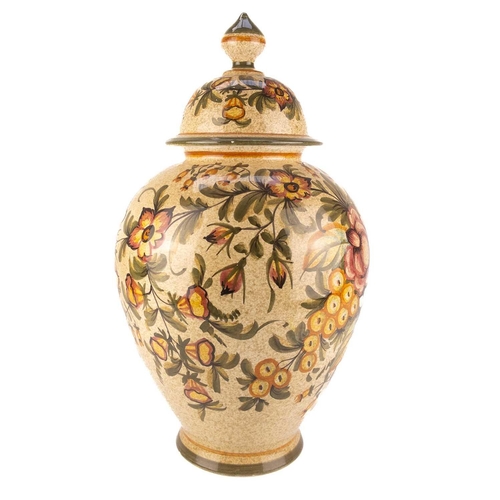 424 - A large continental pottery baluster vase and cover. Decorated with flowers on a speckled ground, he... 