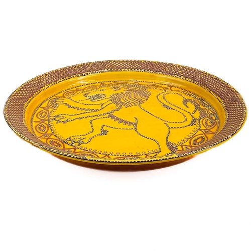 426 - A large studio pottery slipware charger. Decorated a lion rampant and inscribed Paul Spence, diamete... 