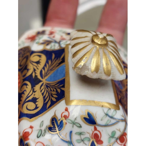 505 - A Bloor Derby circular porcelain teapot and cover. Circa 1820, painted and gilt in the Imari palette... 