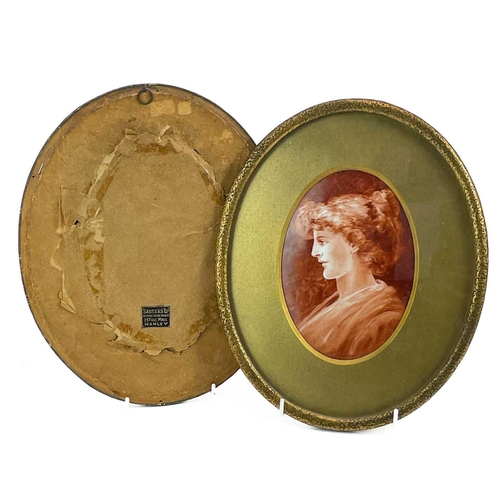 568 - A pair of late Victorian oval painted porcelain portrait plaques. Each with a monochrome female bust... 