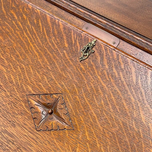 622 - An early 20th century oak bureau. The writing slope opens to reveal an arrangement of drawers and pi... 