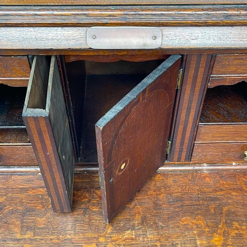 622 - An early 20th century oak bureau. The writing slope opens to reveal an arrangement of drawers and pi... 