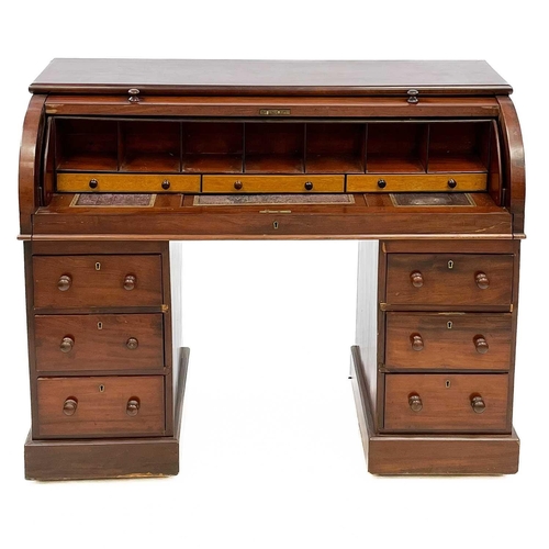 636 - A Victorian mahogany cylinder top desk. Fitted a pull-out slide with drawers and pigeonholes, each p... 