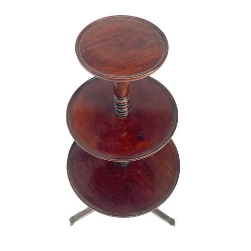 655 - A Regency mahogany three tier circular dumb waiter. With a turned central column on swept tripod sup... 