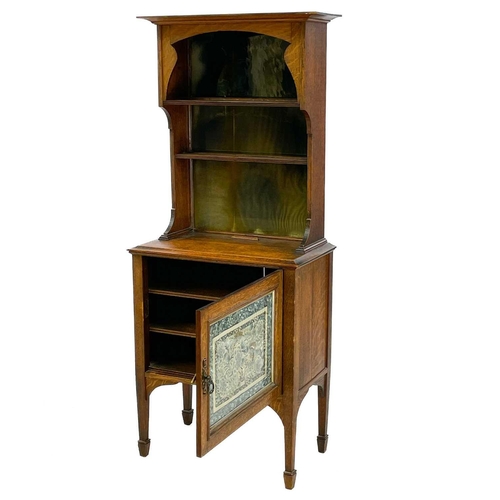 661 - An Arts and Crafts oak dresser, of diminutive size. The rack with shaped sides and glazed silk panel... 