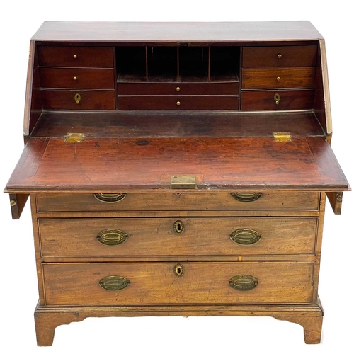 679 - A George III mahogany bureau. The fall front enclosing drawers and pigeonholes, with four graduated ... 