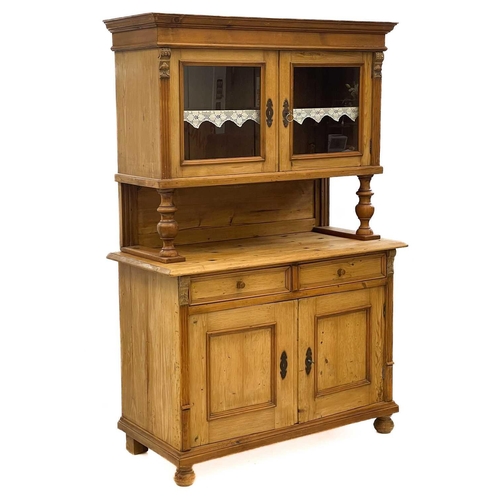 681 - A pine kitchen dresser. 20th century, the upper part with two glazed doors on turned supports, the l... 