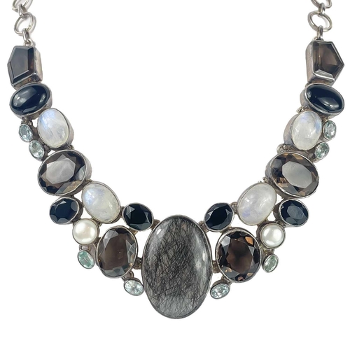 407 - A sterling silver semi precious gem set necklace. Set with tourmalated quartz, moon stone, pearl, bl... 