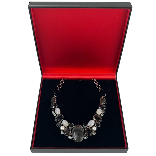 407 - A sterling silver semi precious gem set necklace. Set with tourmalated quartz, moon stone, pearl, bl... 