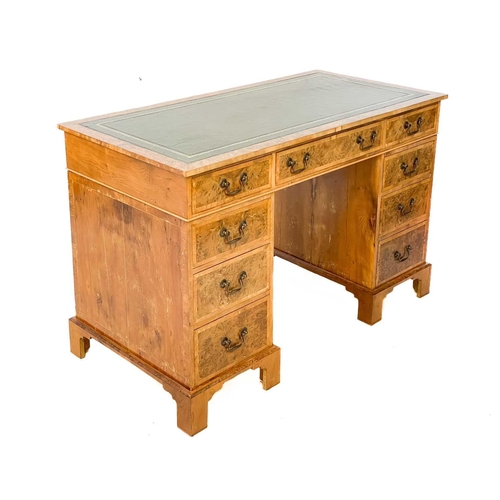 105 - A 20th century figured yew pedestal desk by Abbey Reproductions, Penzance. With a green tooled leath... 