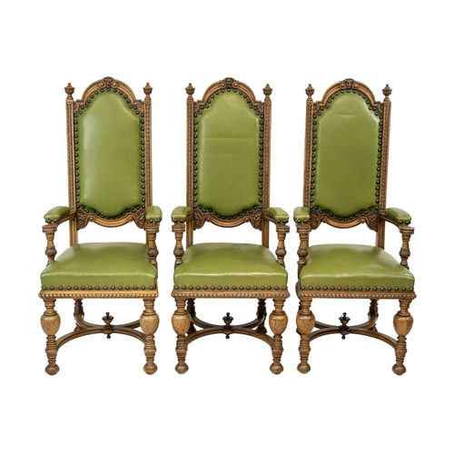 18 - A set of eight carved oak elbow chairs. Circa 1920, the top rails with carved mask decoration, padde... 