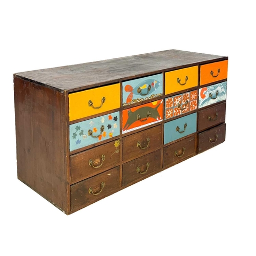 26 - A bank of 16 late Victorian stained and later painted pine drawers. Height 56cm, width 122.5cm, dept... 