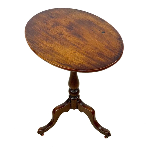 30 - A Victorian oval mahogany wine table. With tilt top, raised on a baluster turned pillar and tripod b... 