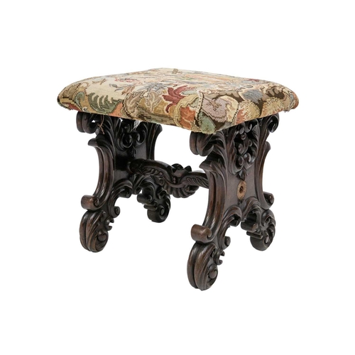 39 - A continental walnut stool. 19th century, with a padded top, on leafy scroll and foliate carved supp... 