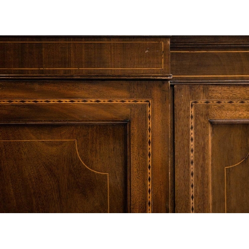 43 - An Edwardian mahogany inlaid breakfront wardrobe. The central section with linen press above two sho... 