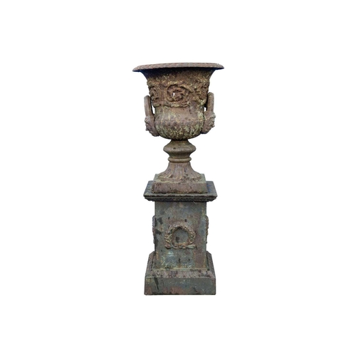 526 - A classical style cast iron garden urn on stand. Early 20th century, of campana form, with gadrooned... 