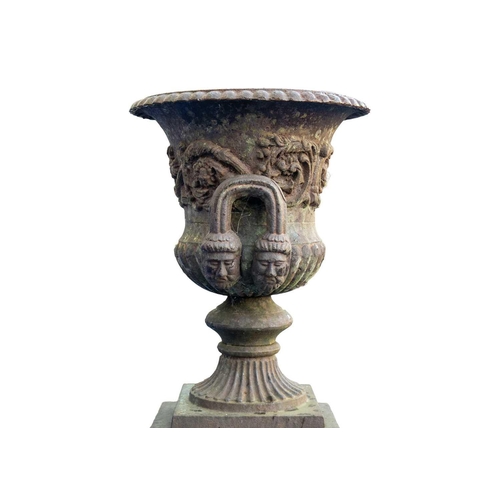 526 - A classical style cast iron garden urn on stand. Early 20th century, of campana form, with gadrooned... 