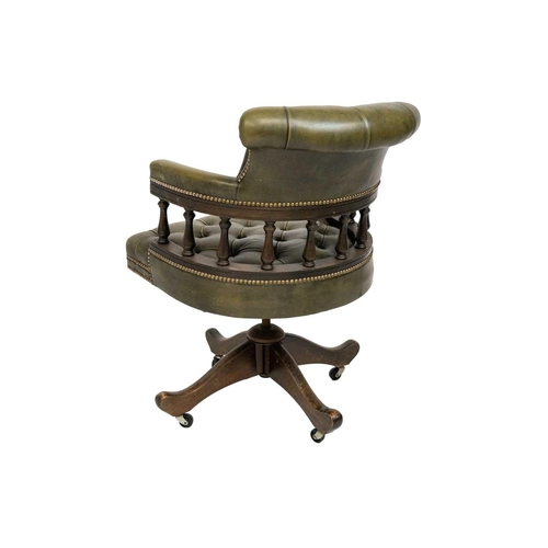 65 - A button backed green leather captain's swivel chair. On castors, height 87cm width 63cm depth 65cm.