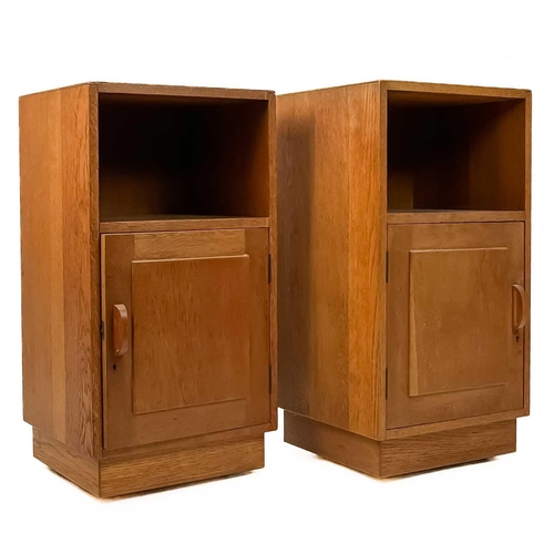 83 - Gordon Russell (1892-1980) A pair of oak bedside cabinets with an open shelf above a single cupboard... 