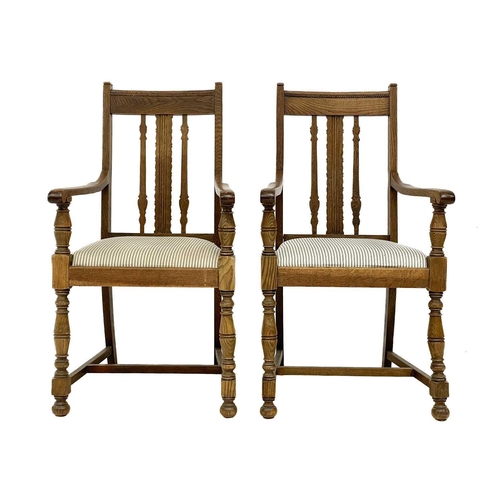 86 - A pair of Arts and Crafts oak armchairs. With drop in seats on turned supports and bun feet, height ... 