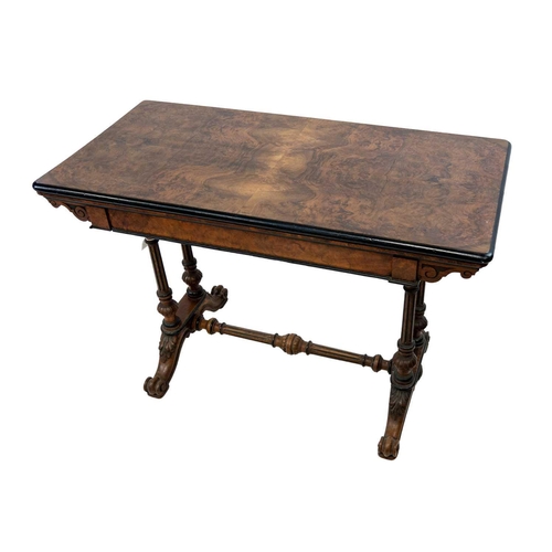 99 - A Victorian burr walnut and ebonised fold over swivel top card table. The top of rectangular form wi... 