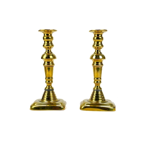121 - A pair of 19th century brass candlesticks. With faceted knop, height 24cm together with four other p... 