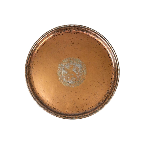 122 - An Arts and Crafts copper charger by Hugh Wallis. A central rampant lion with oak leaf and acorn bor... 