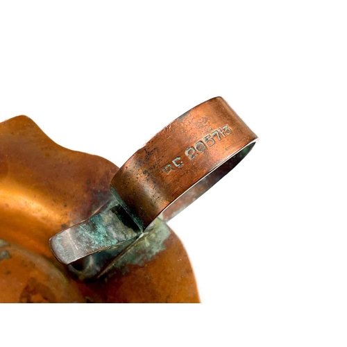 125 - A copper chamberstick by Henry Loveridge. Diameter 18cm, together with an Art Nouveau copper and bra... 