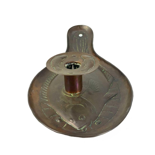 127 - An Arts and Crafts Newlyn copper candleholder. Repousse decorated with a plaice, the wax guard furth... 